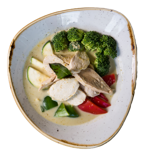 Overhead image of a white bowl Gang Kiew Wan (Green Curry) made with chicken slices, and fresh seasonal Thai vegetables in a green curry sauce with coconut milk.